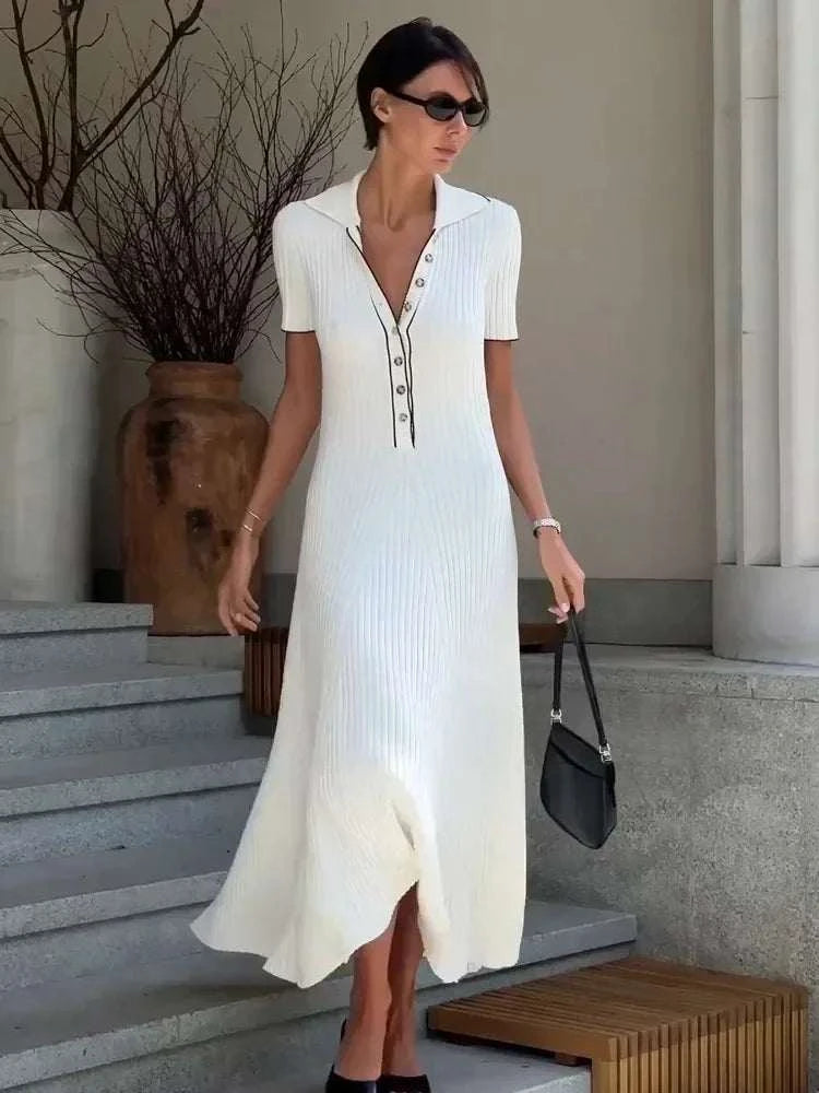 Woman wearing TOSSY white maxi dress with short sleeves and button-front detail carrying black handbag